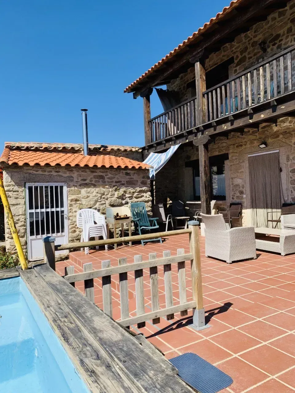 Una valla rodea una piscina delante de una casa.