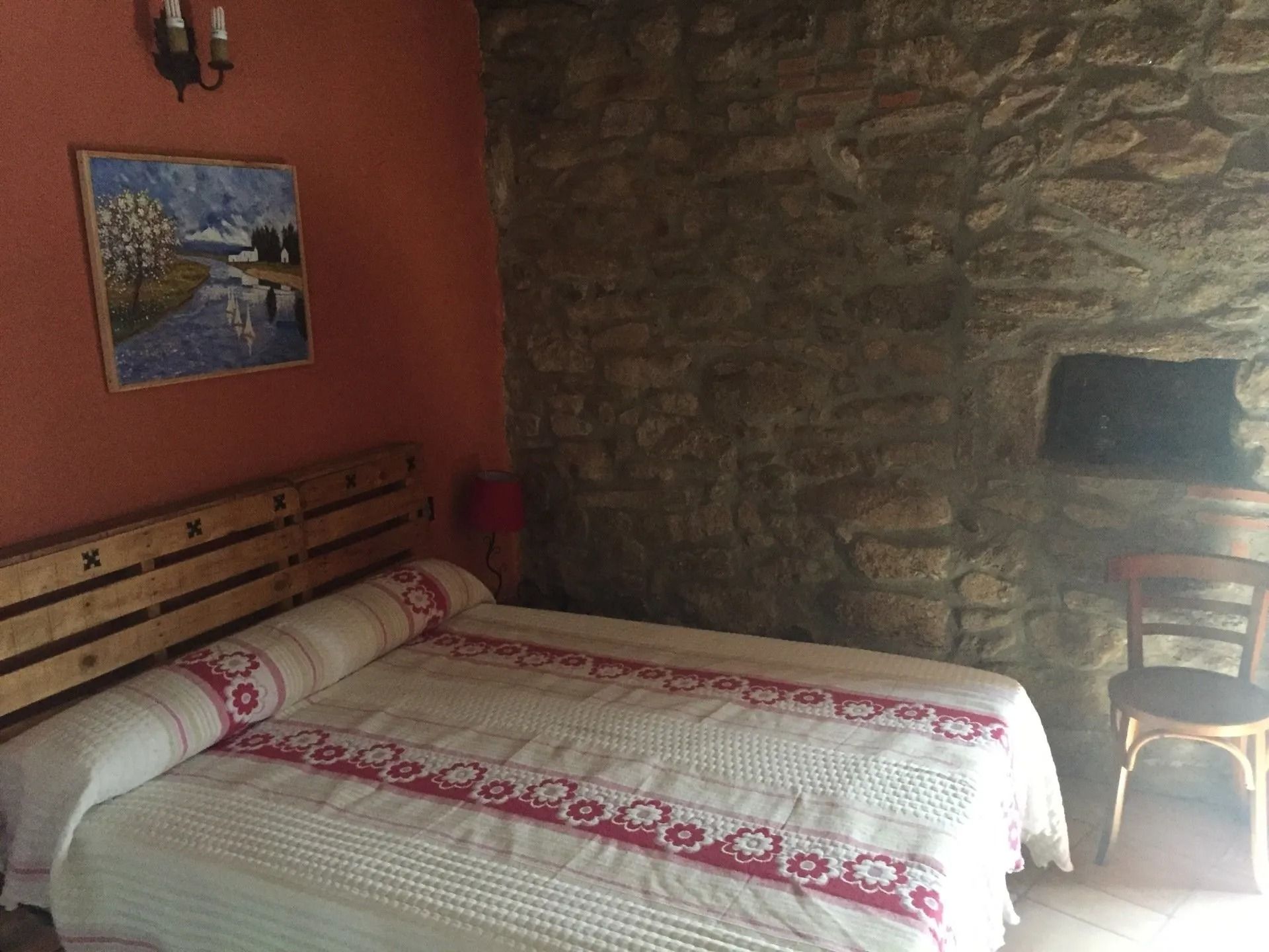 Un dormitorio con una cama y un cuadro en la pared.