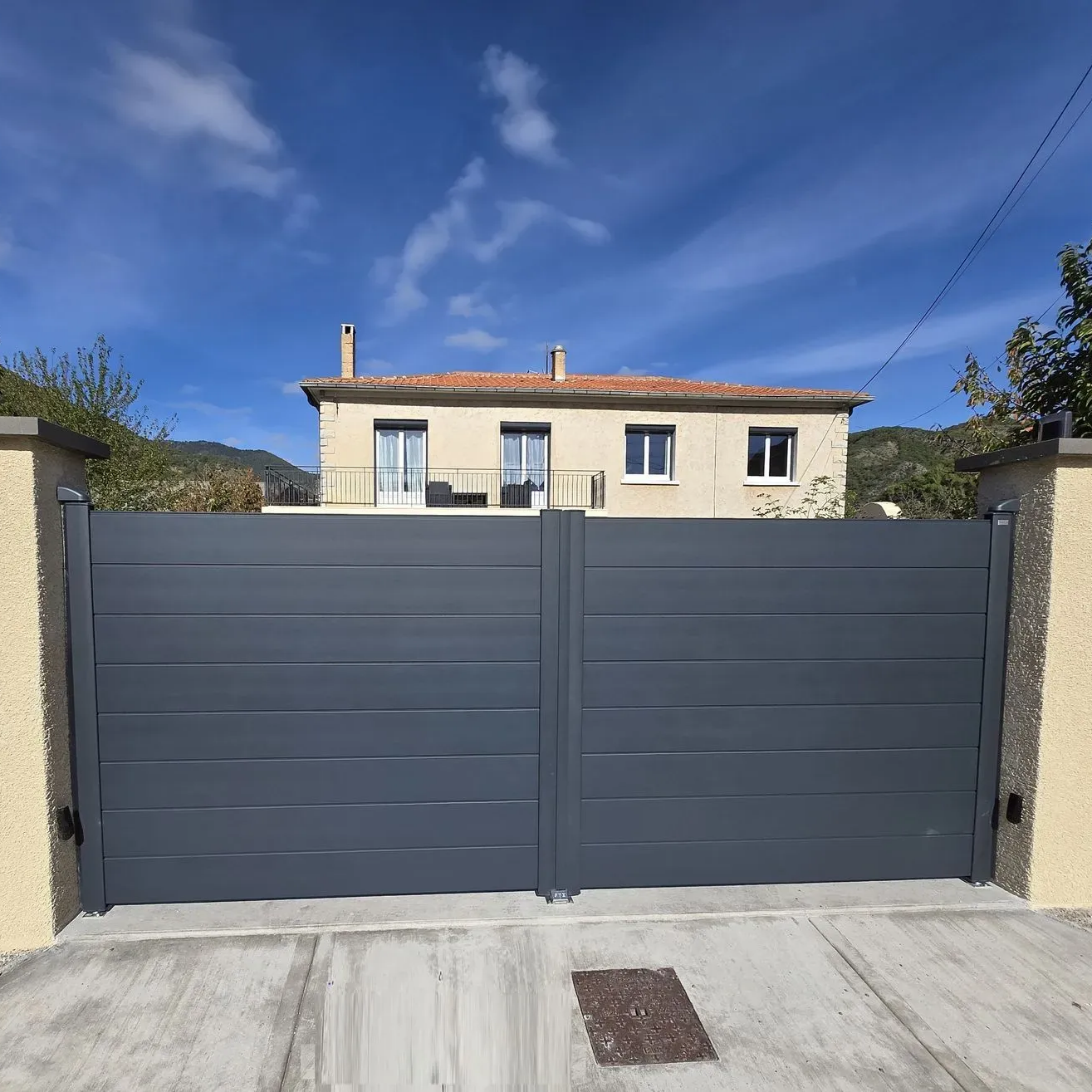 Portail battant blanc fermant la cour d'une maison