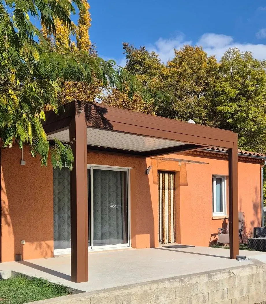 Pergola marron adossée à la maison et abritant une terrasse