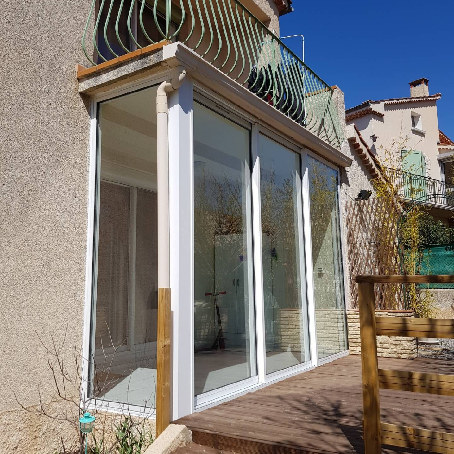 Véranda créée depuis un espace sous balcon et une baie vitrée