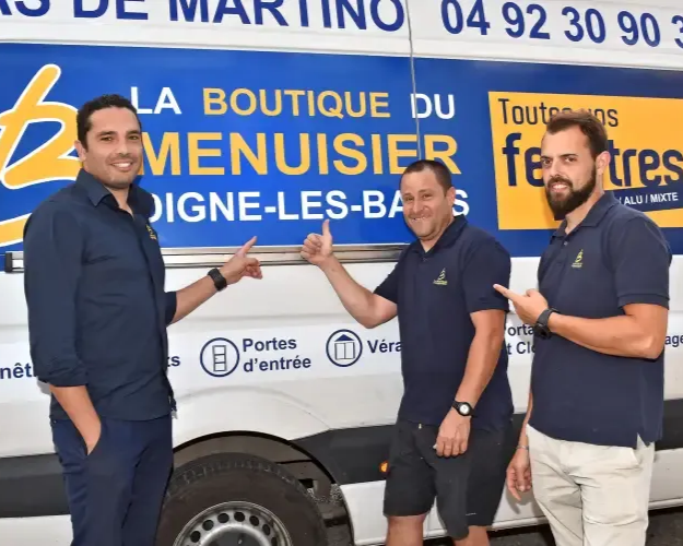 Trois hommes pointent du doigt une camionnette blanche marquée de la charte graphique de 