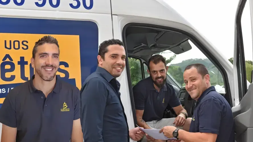Quatre hommes se tiennent devant une camionnette blanche 