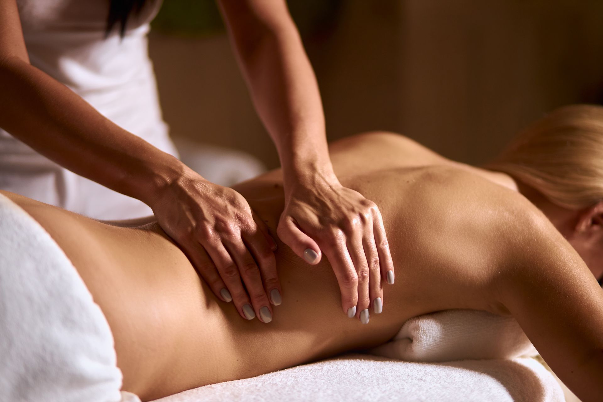 Eine Person geniesst in einem Spa eine entspannende Rückenmassage von einem Therapeuten.