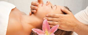 Eine Person, die auf dem Bauch liegend auf einer professionellen Massageliege eine Rückenmassage erhält.