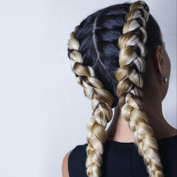 Une femme de dos avec des tresses blondes et noires