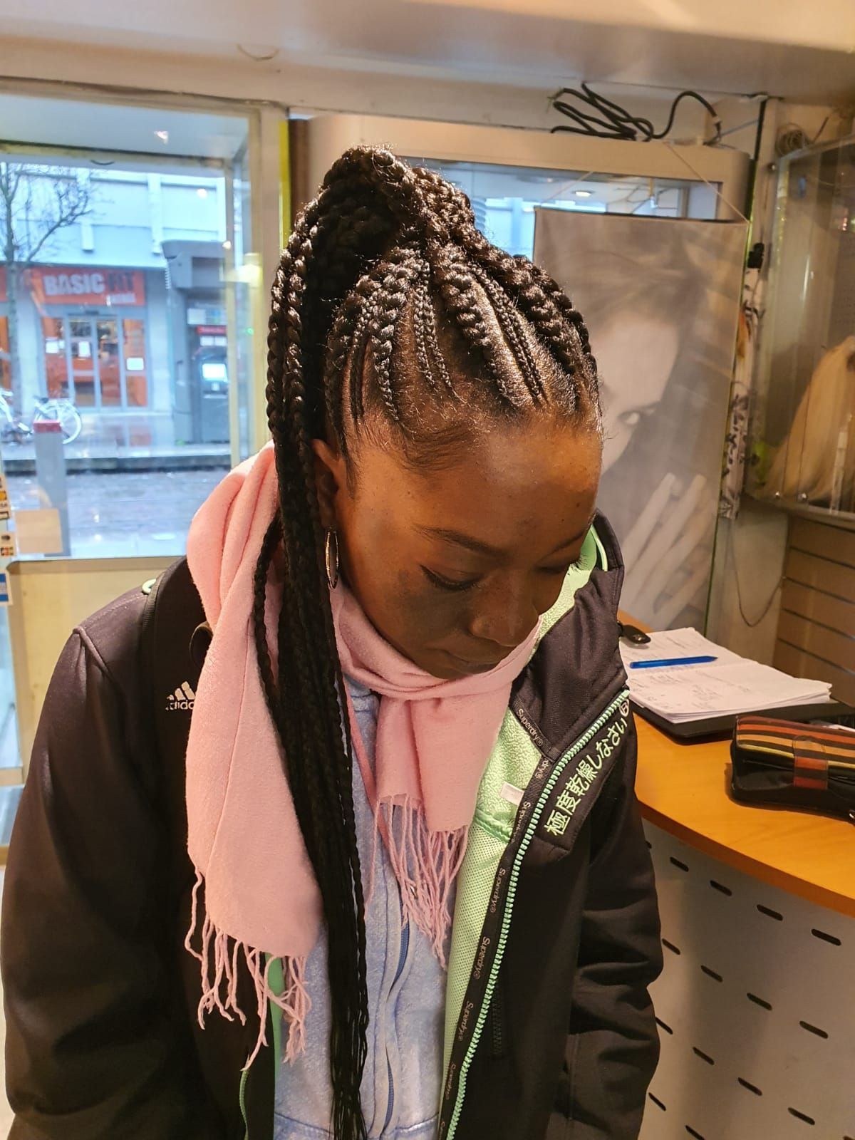 Une femme avec des tresses et une écharpe rose