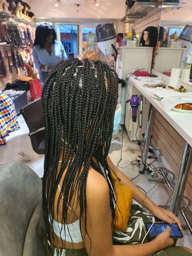 Une femme avec des tresses dans un salon de coiffure