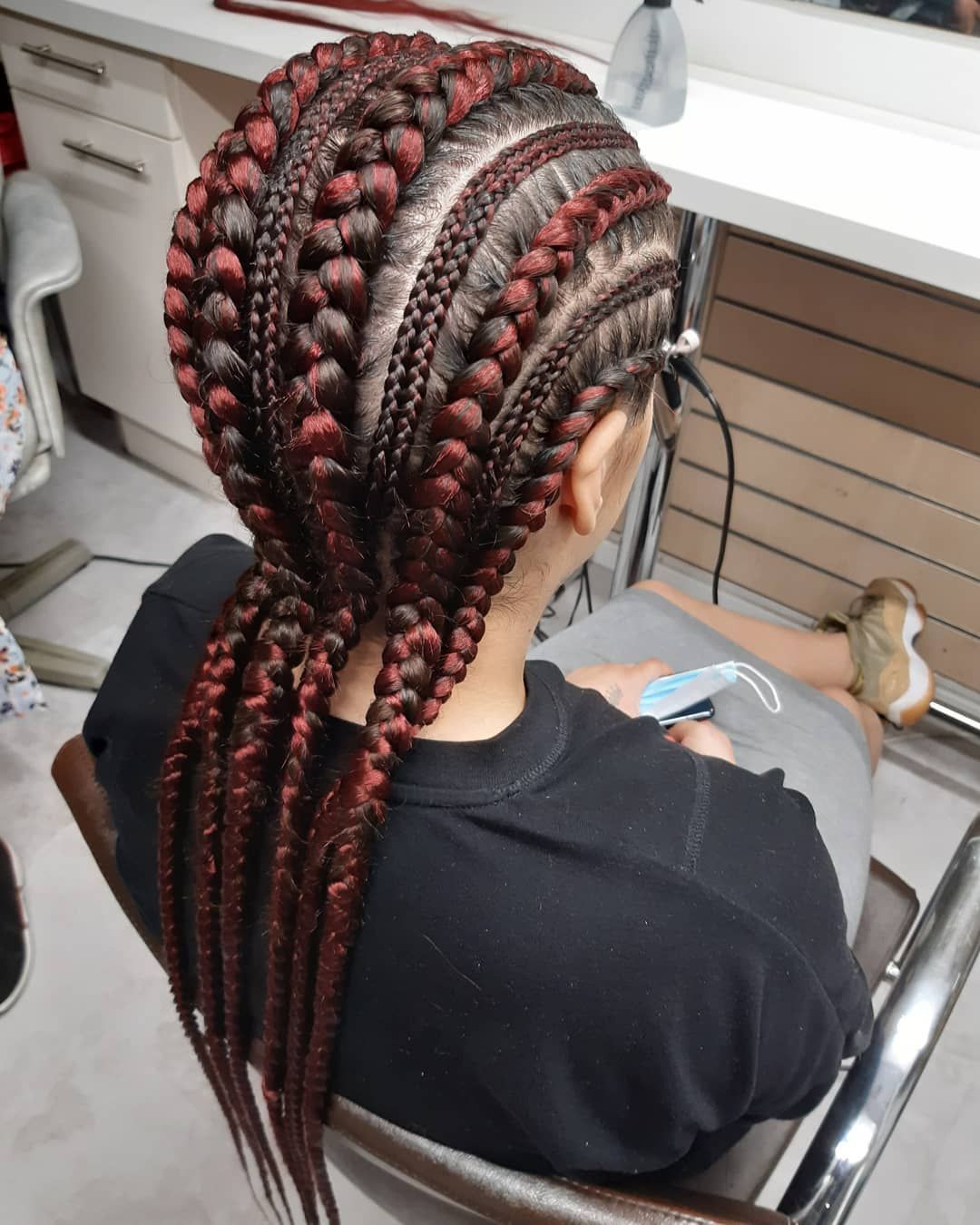 Une femme avec des tresses rouges et noires