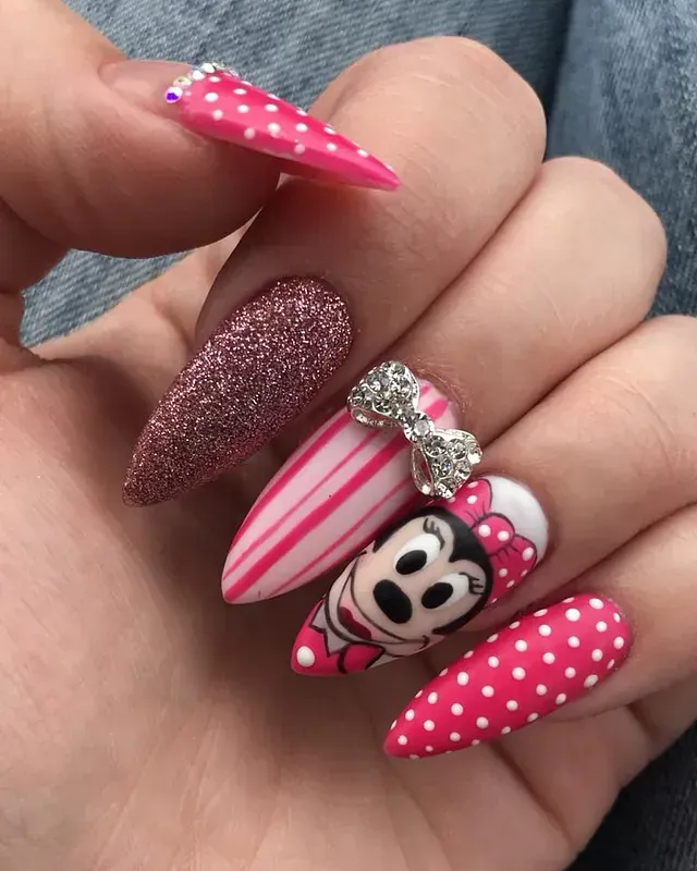 Un primer plano de las uñas de una persona con un diseño de Minnie Mouse.