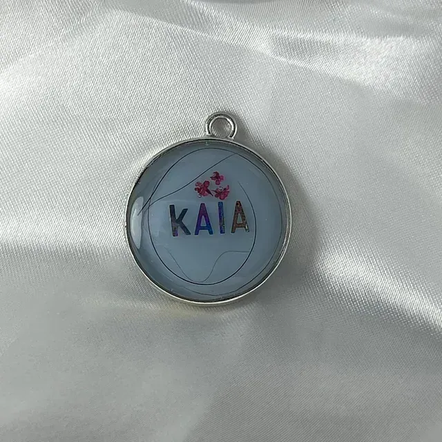 Un colgante con el nombre Kaia está sobre un paño blanco.