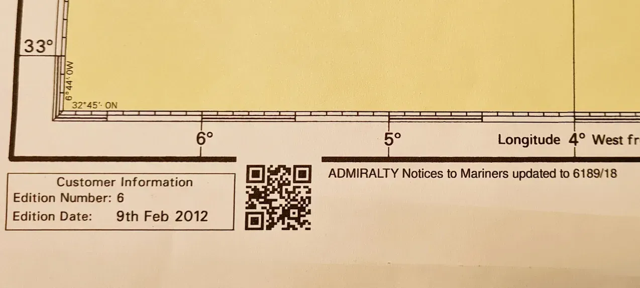 Sección de una esquina de una carta náutica de navegación que muestra las líneas de la cuadrícula de coordenadas, los detalles de la edición y un código QR.