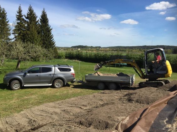 Kaivinkone nostaa maa-ainesta lava-auton peräkärryyn