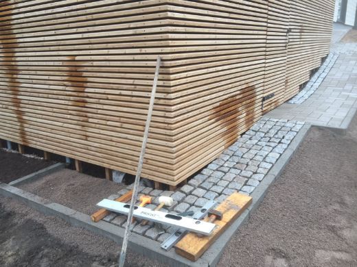 Ulkorakennuksen kylkeen rakennettaan kivetystä