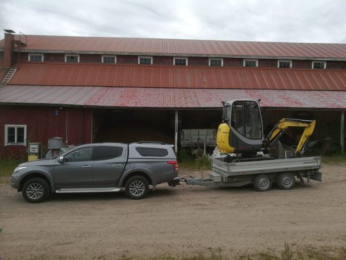 Pienkaivinkone lava-auton peräkärryssä