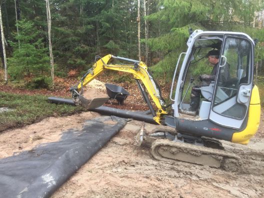  Kaivinkone siirtää maa-ainesta pihalla