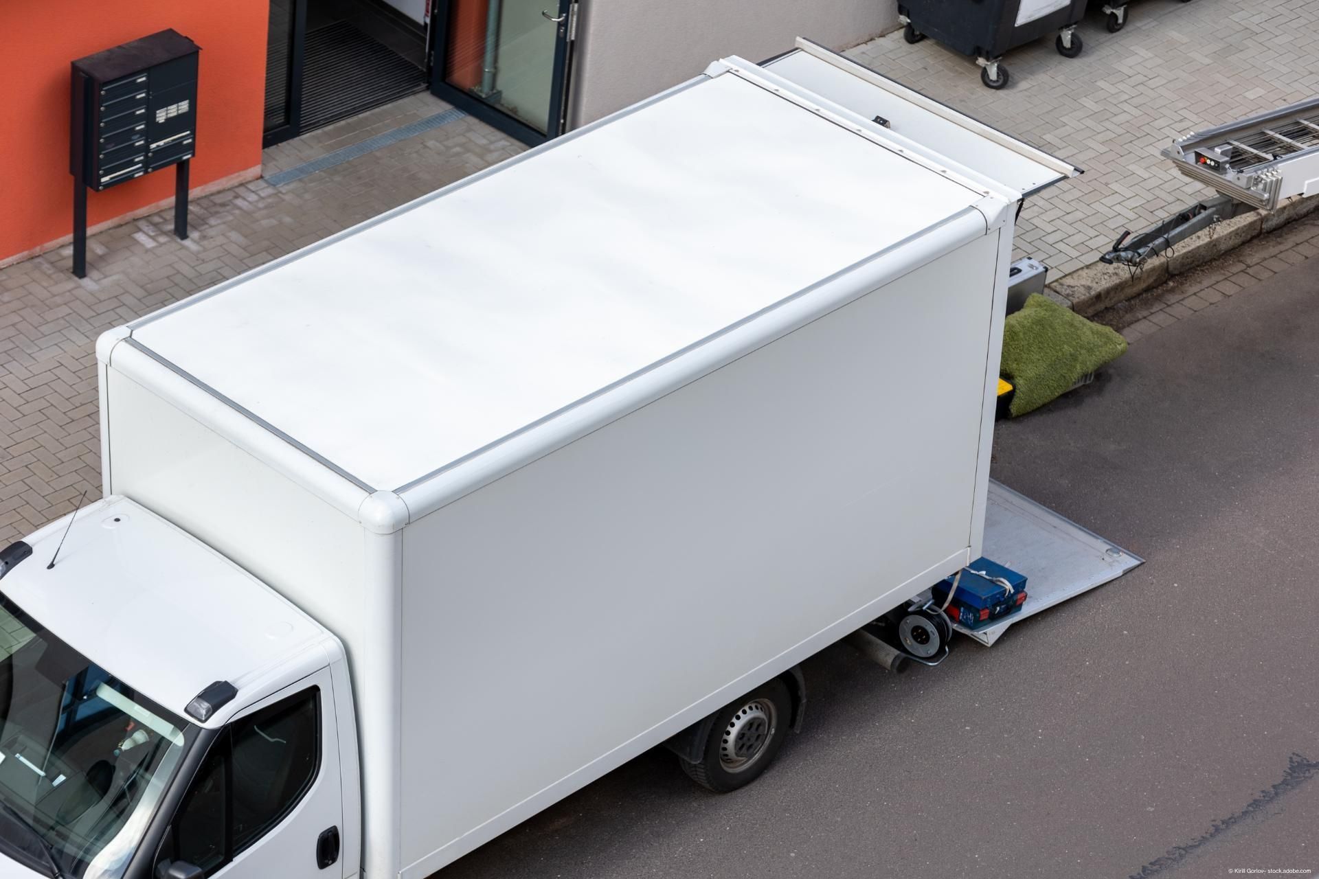 Ein weißer Transporter steht offen vor einer Wohnung Ein weißer Transporter steht offen vor einer Wohnung