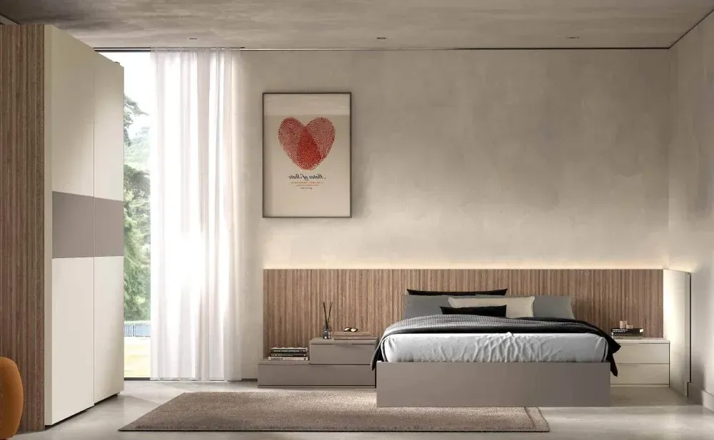 Hay una imagen de un corazón en la pared encima de la cama.