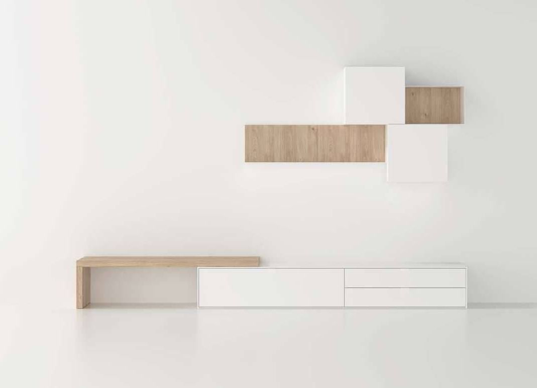 Una pared blanca con un estante de madera encima.