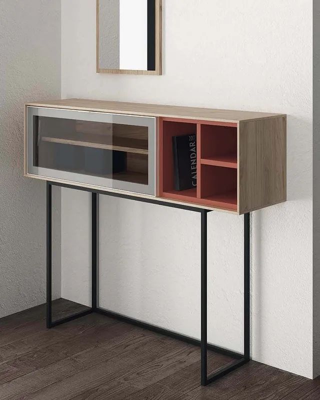 Una consola de madera con un espejo y un libro encima.