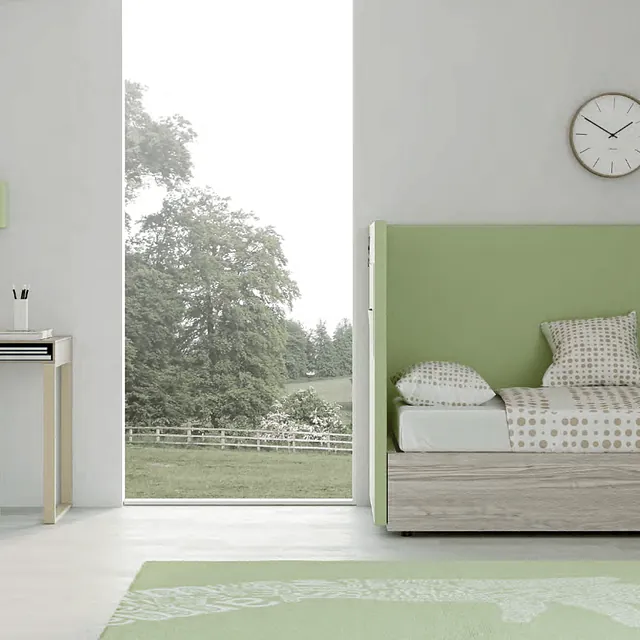 Un dormitorio con una cama verde y un reloj en la pared.