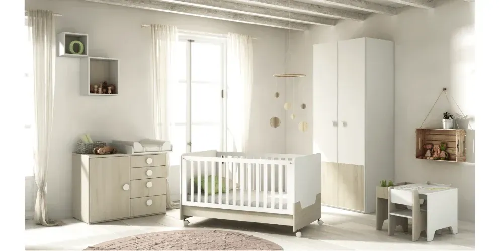 Una habitación de bebé con cuna, tocador, escritorio y sillas.