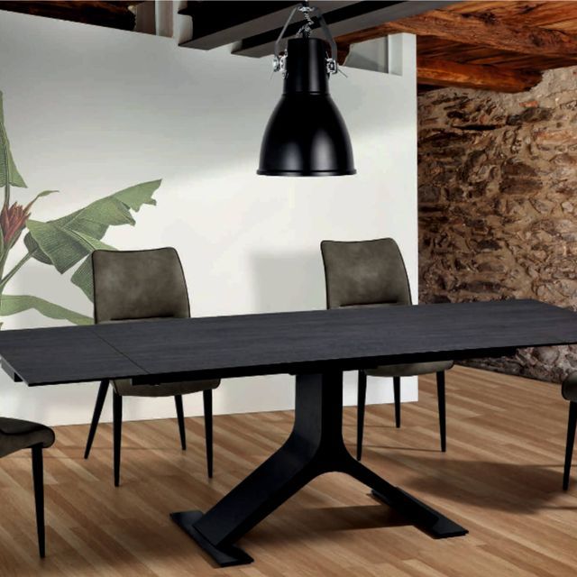 Un comedor con una mesa y sillas negras.