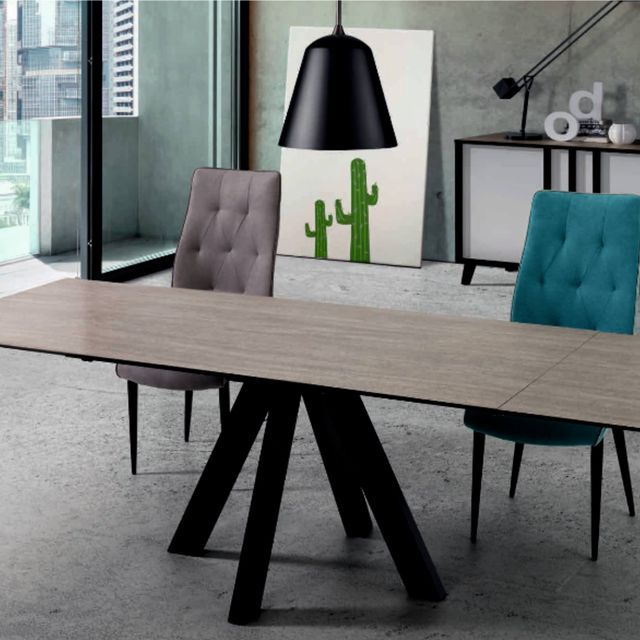 Una habitación con una mesa y sillas y una imagen de un cactus en la pared.