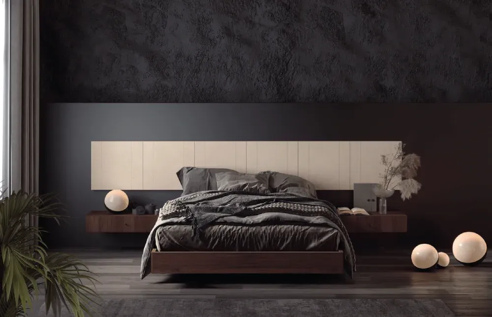 Un dormitorio con una cama, mesitas de noche, lámparas y una pared negra.