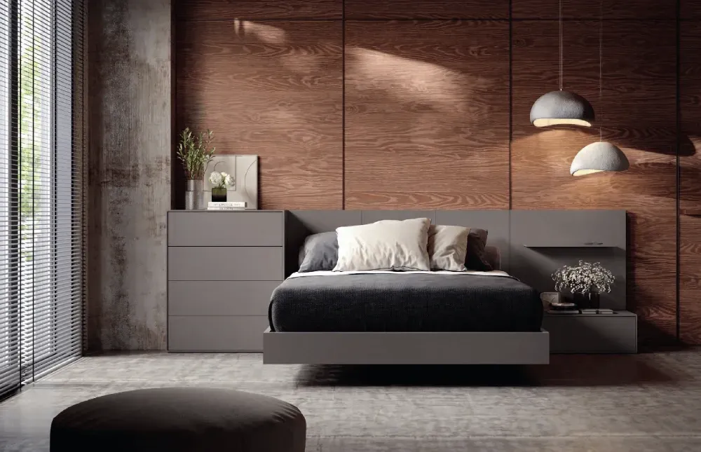 Un dormitorio con una cama, mesita de noche y otomana.