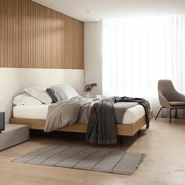 Un dormitorio con una cama grande y una silla.