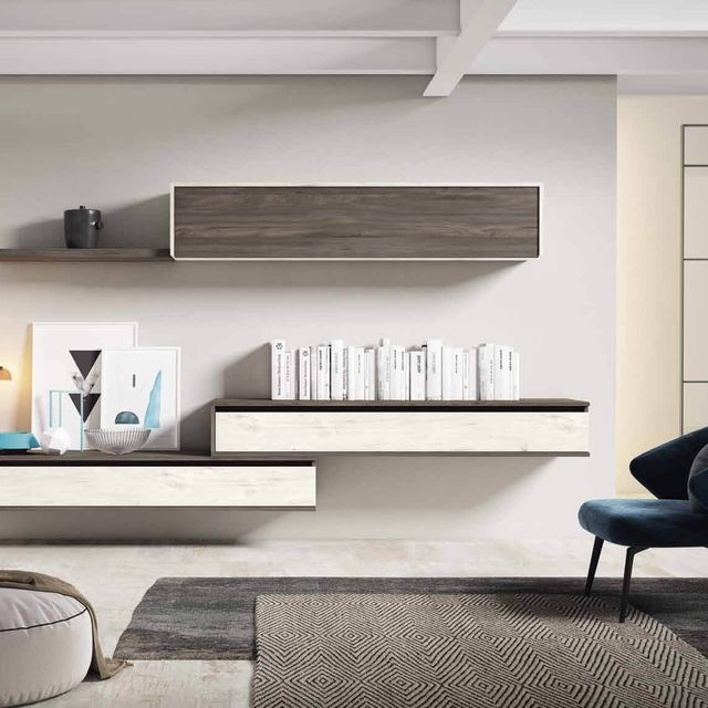 Una sala de estar con una silla y un estante con libros encima.
