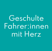 Die Hand einer Person am Rad eines Rollstuhls in einem hell erleuchteten Flur.