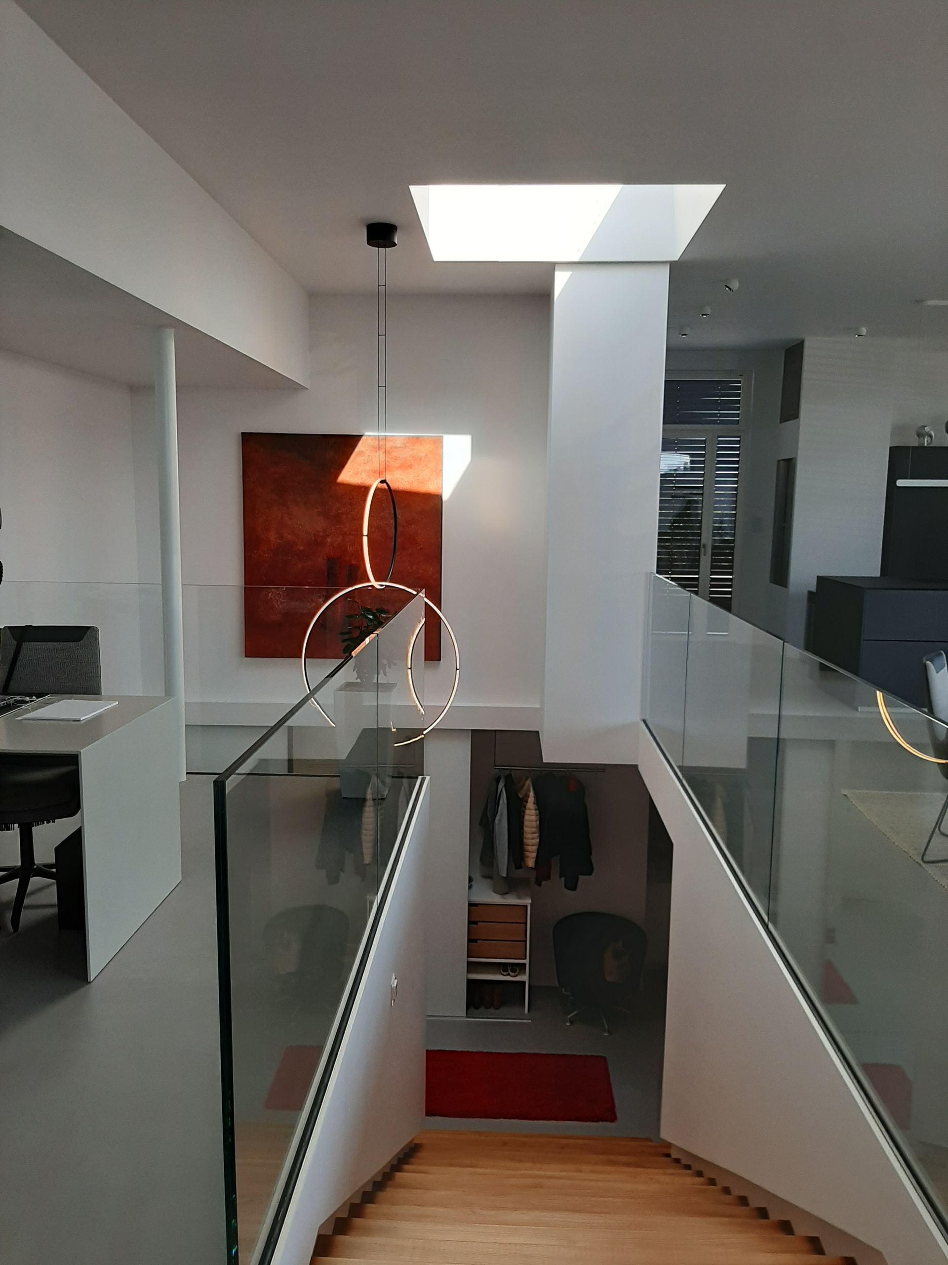 Modernes zweistöckiges Gebäude in Weiß und Beige mit schmalen Fenstern und einem Bürgersteig davor