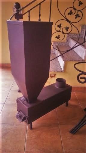 Una pequeña estufa está colocada sobre un suelo de baldosas al lado de una escalera.