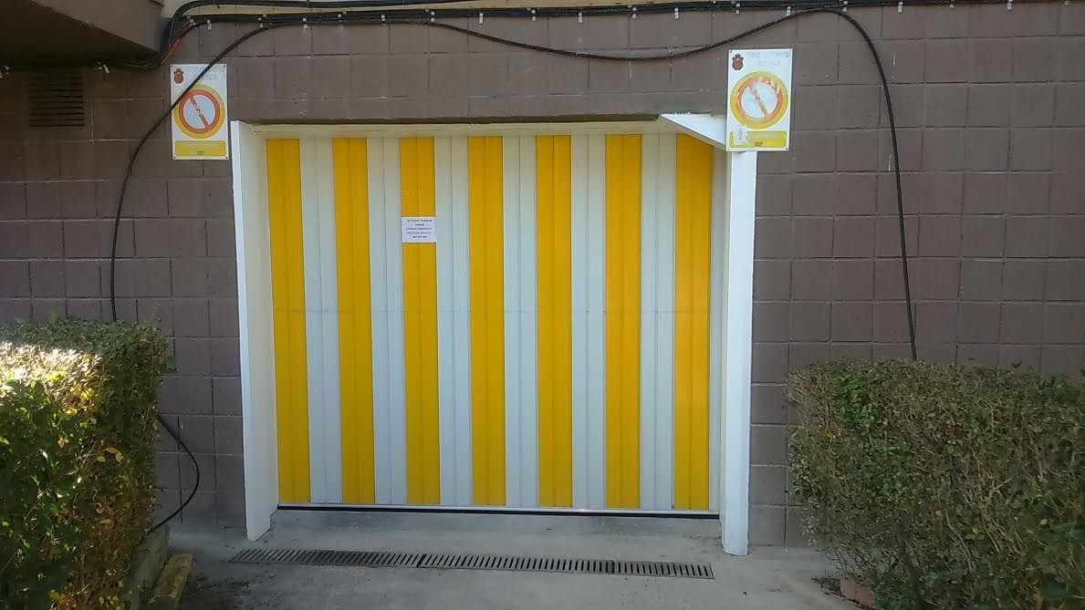 Una puerta de garaje con rayas amarillas y blancas está abierta