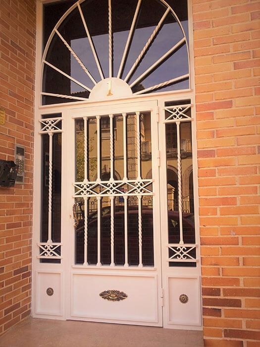 Una puerta blanca con una pared de ladrillos detrás.