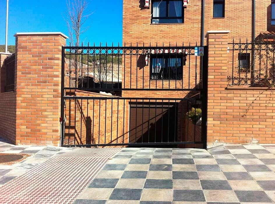 Un edificio de ladrillo con una puerta negra delante.