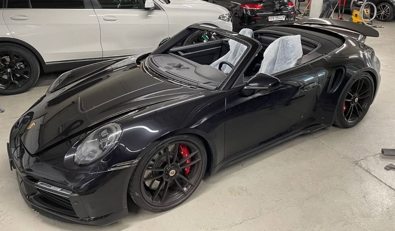 Ein schwarzes Porsche 911 Turbo S Cabrio steht in einer Garage. Foto von der RR-Carrosserie GmbH