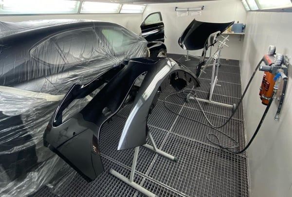 In einer Lackierkabine wird ein Auto lackiert. Foto von der RR-Carrosserie GmbH