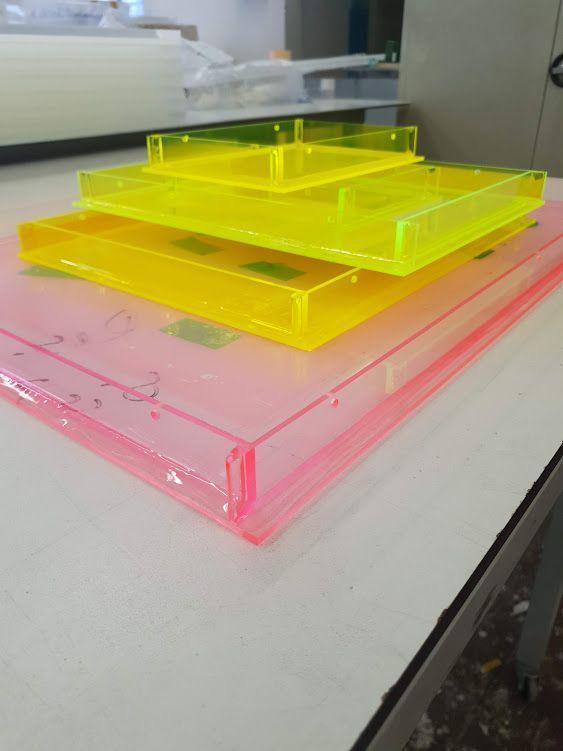 Mehrschichtige, gelbe Acrylplatten in rechteckiger Form auf einer Werkbank.