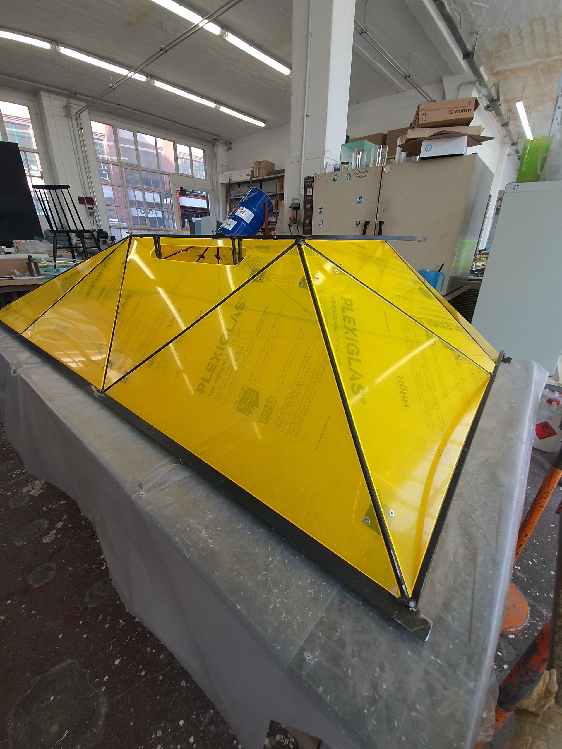 Große gelbe, geometrische Kunststoffform in einer industriellen Werkhalle.