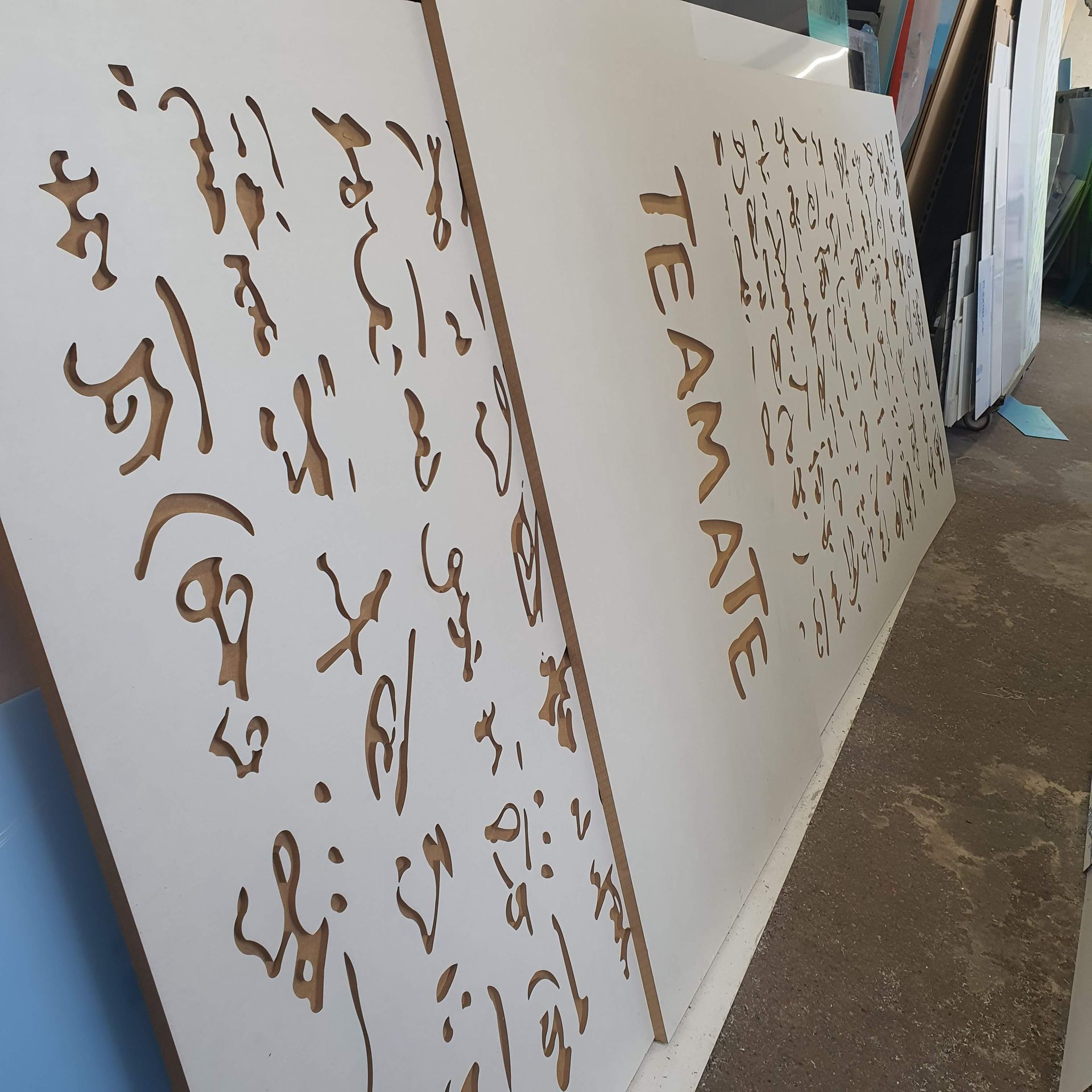 geometrische Platte mit asiatischer Schrift aus Metall oder Kunststoff in einer Werkstatt.