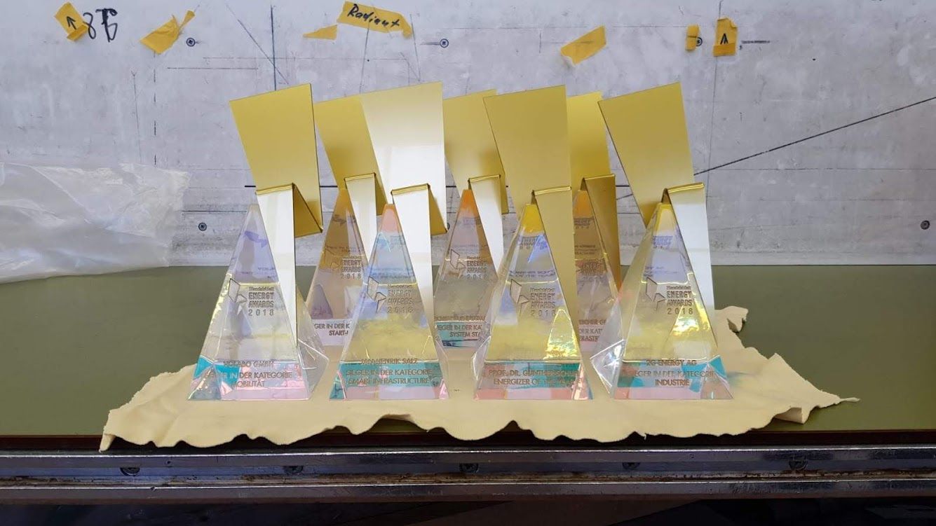 Mehrere spiegelnde, dreieckige Pokale zu 