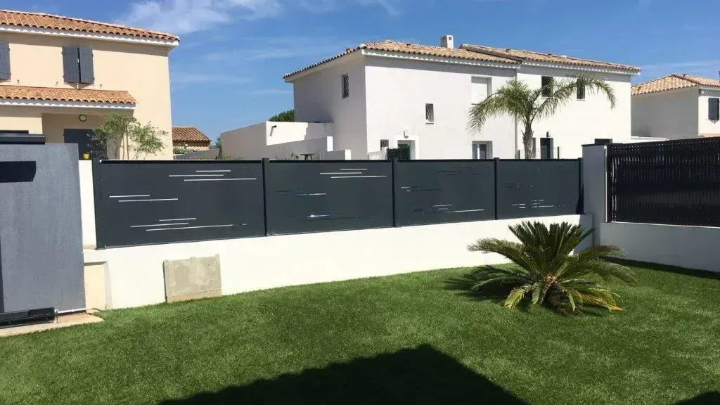 Clôture grise posée sur un muret