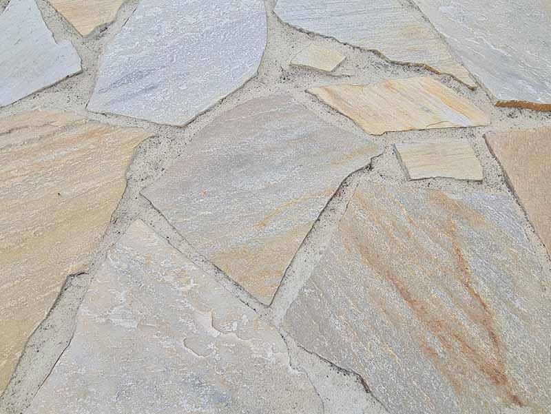 Eine Nahaufnahme eines Steinbodens mit vielen verschiedenfarbigen Fliesen.