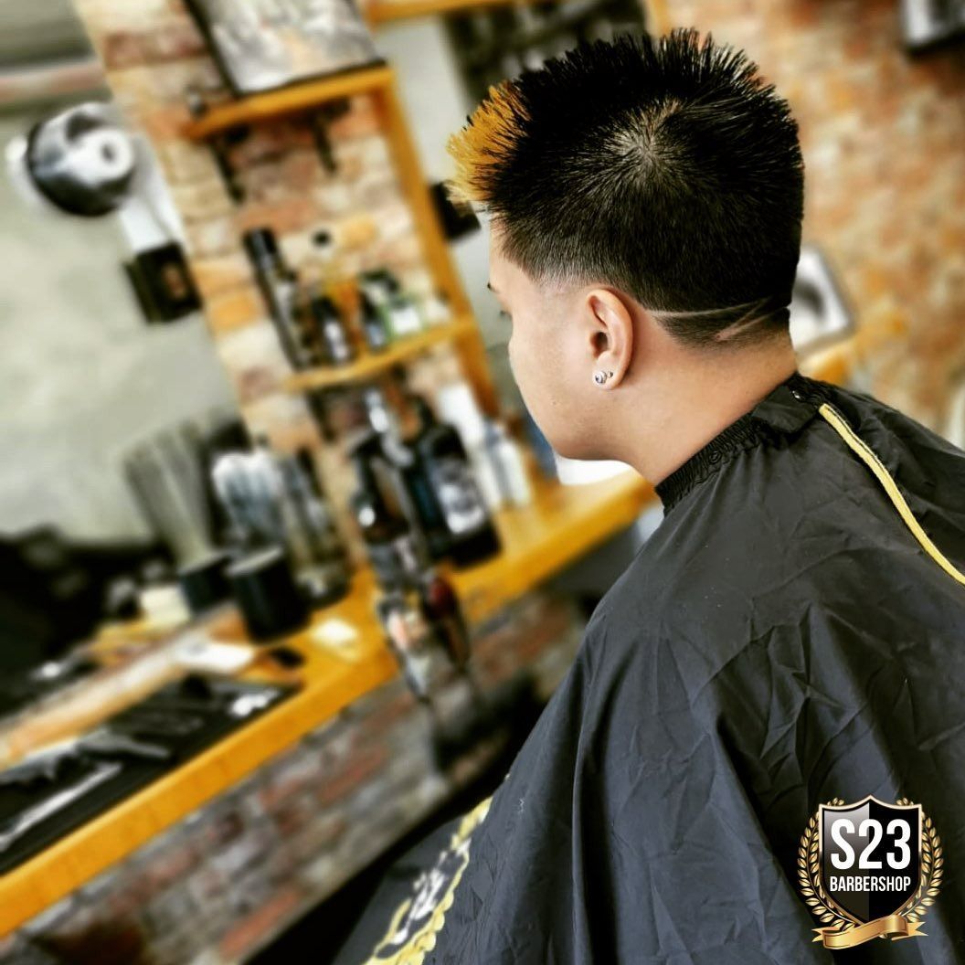 Un hombre se corta el pelo en una barbería por 23 dólares.