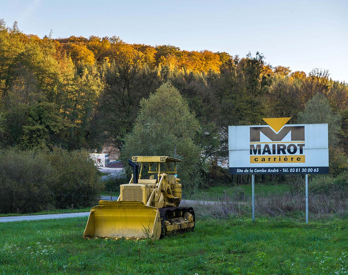 Bulldozer garé devant le panneau de la carrière Mairot