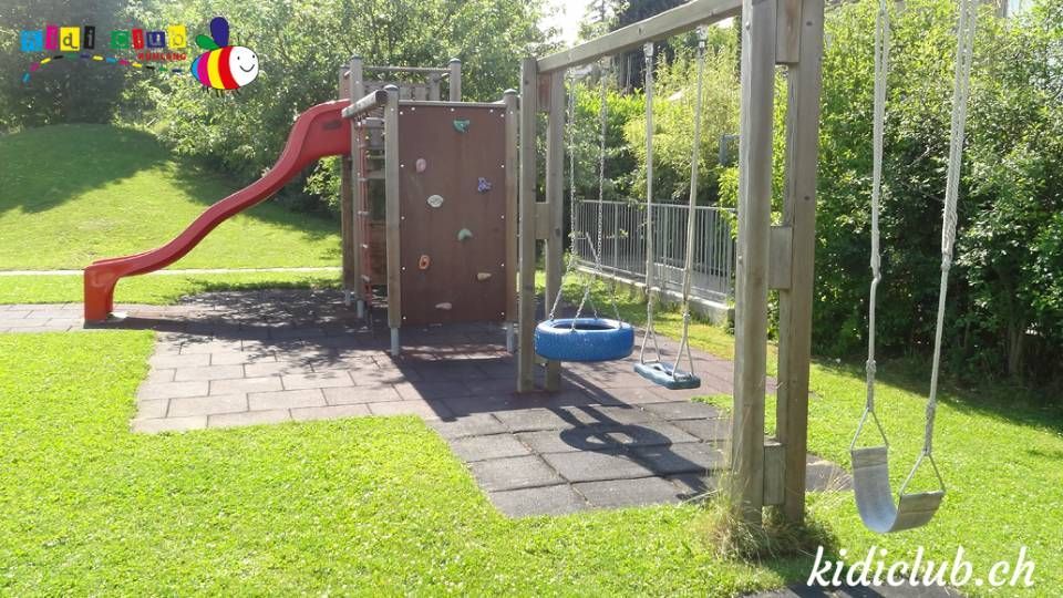 Ein Spielplatz mit Rutsche, Schaukeln und Reifenschaukel.