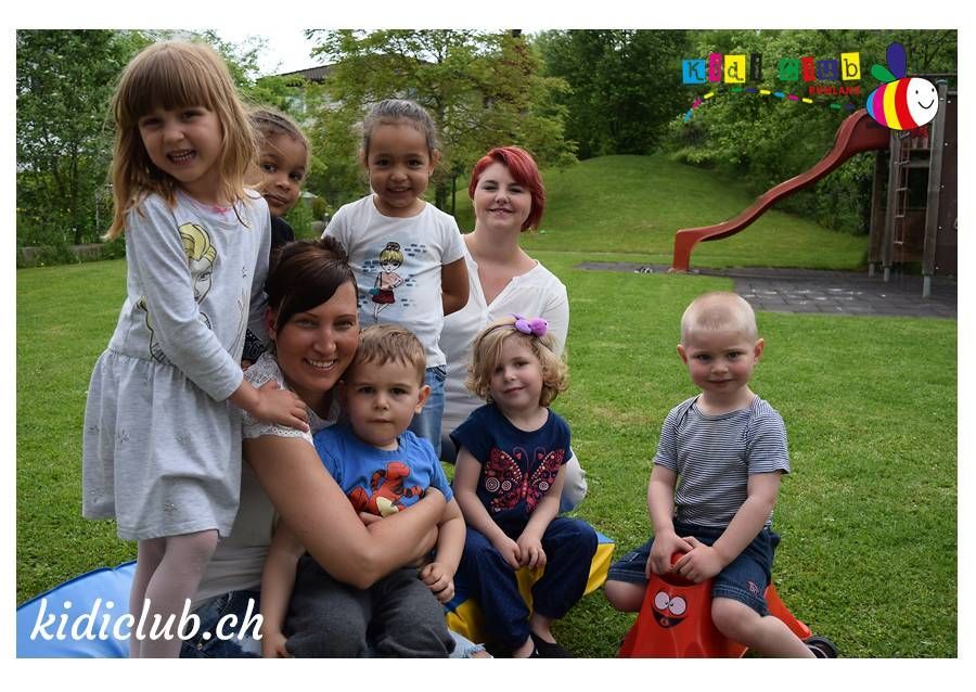Eine Gruppe Kinder posiert in einem Park für ein Foto.